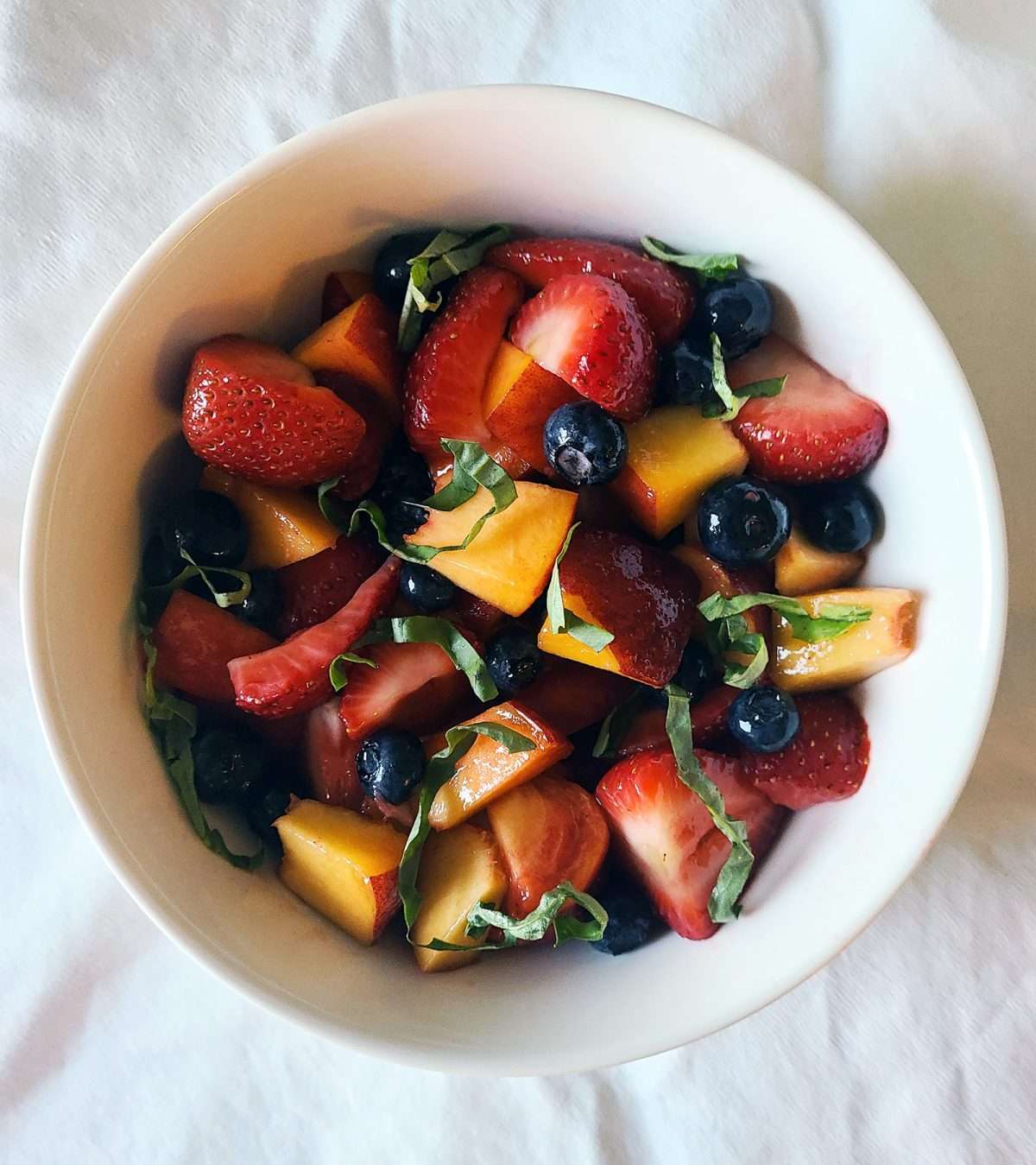 Peach and berry salad with basil and honey lime dressing